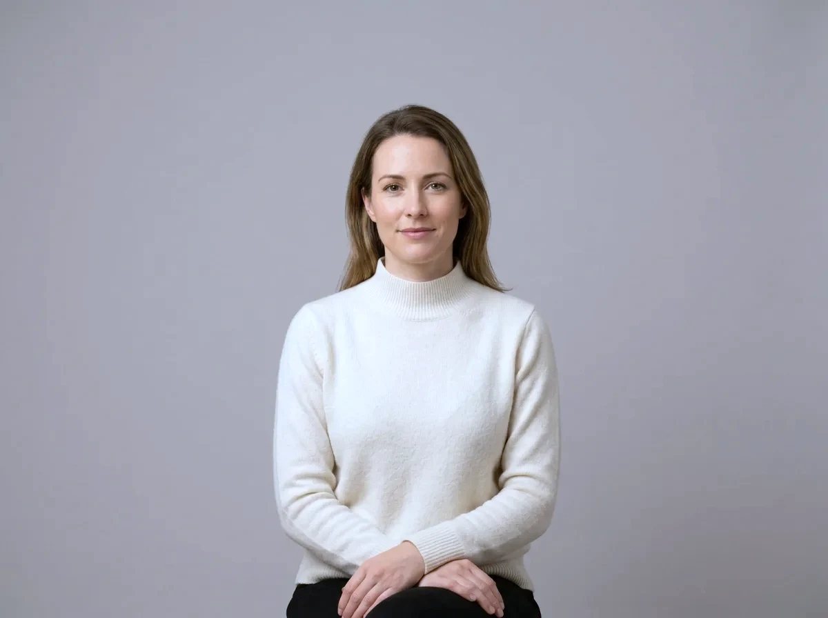 A woman sitting calmly and composed with her hands resting in her lap